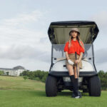 A woman standing in front of a golf cart