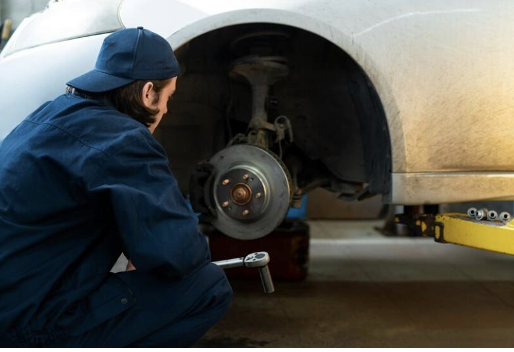 Mechanic inspecting car brake pads for wear and damage