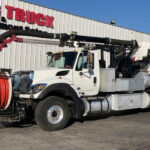 Worker operating a vacuum truck with safety features in place