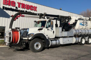 Worker operating a vacuum truck with safety features in place